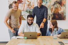 Group of people having fun looking at laptop